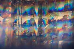 People sitting distorted by rainbow