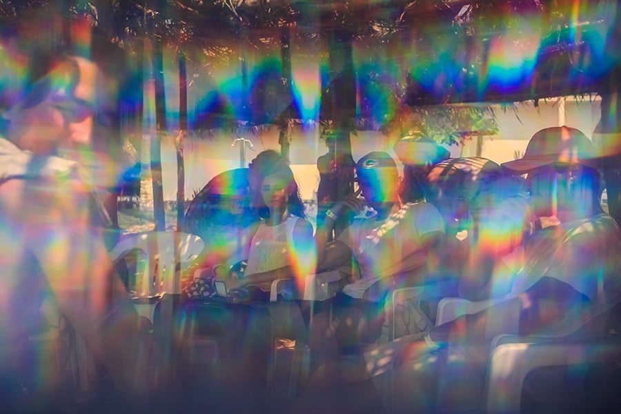 People sitting distorted by rainbow