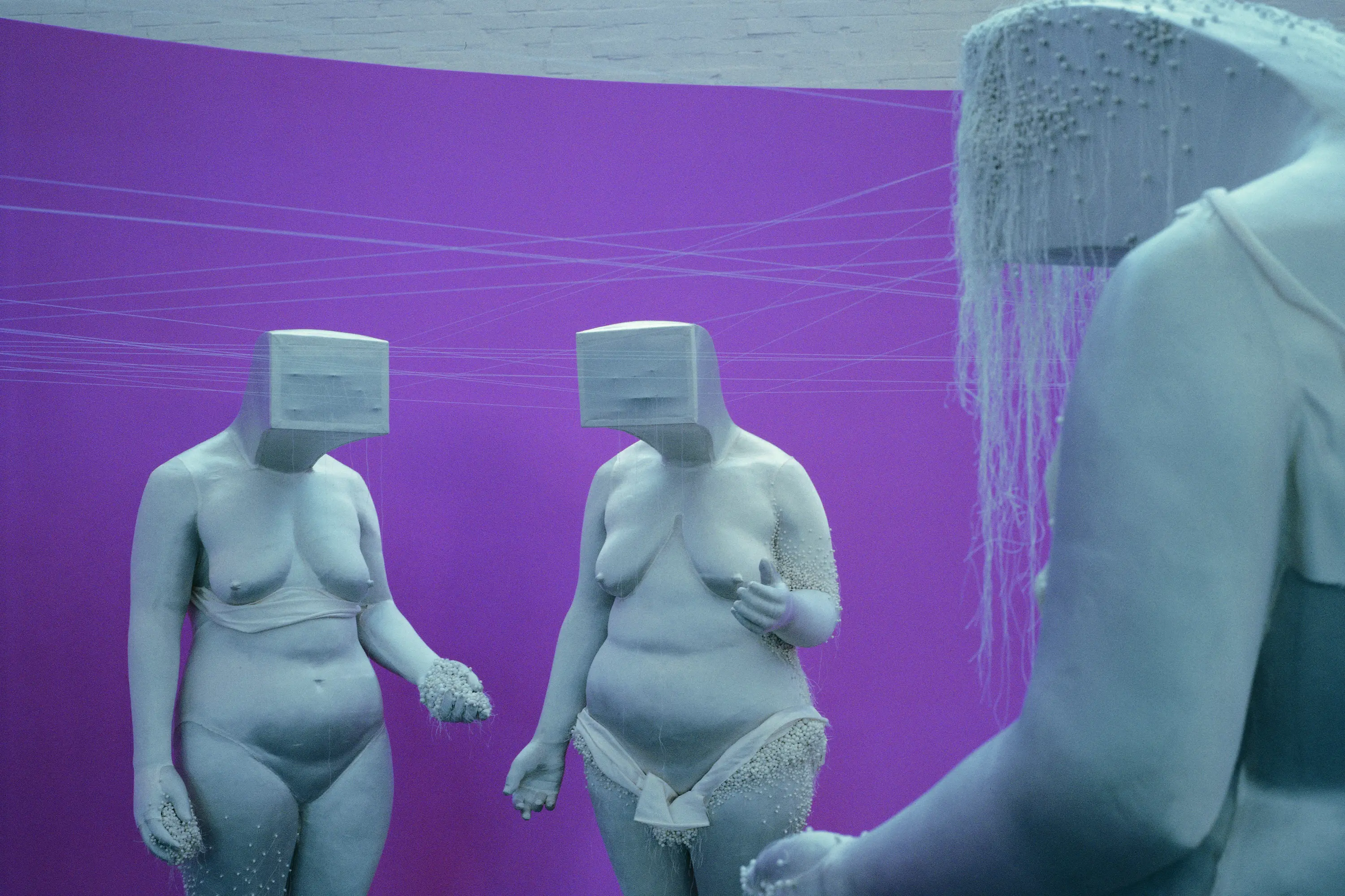 Naked female sculptures with boxes on their heads