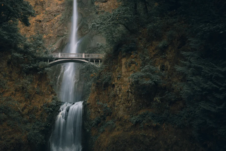 Image Depicting Scenic Waterfall Behind Bridge