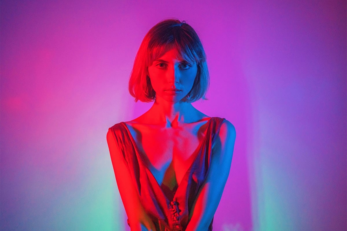 Liara Roux headshot in neon lights