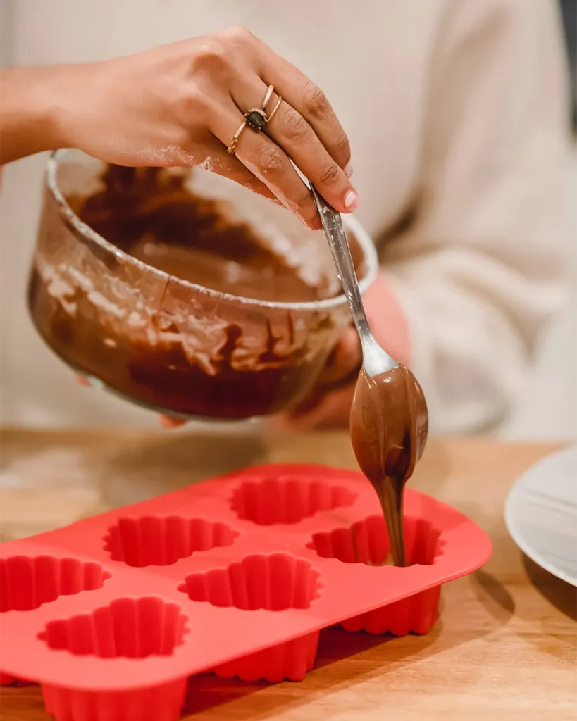 person pouring chocolate into molds