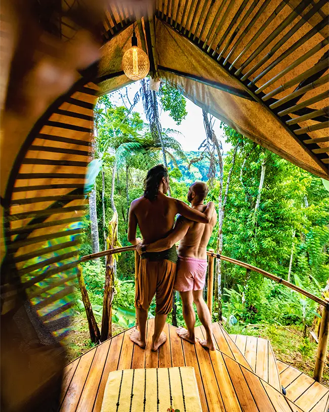 people embracing in jungle hut