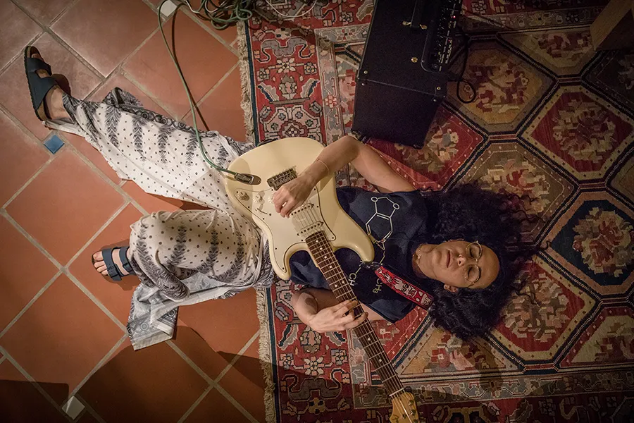 woman laying on ground with guitar