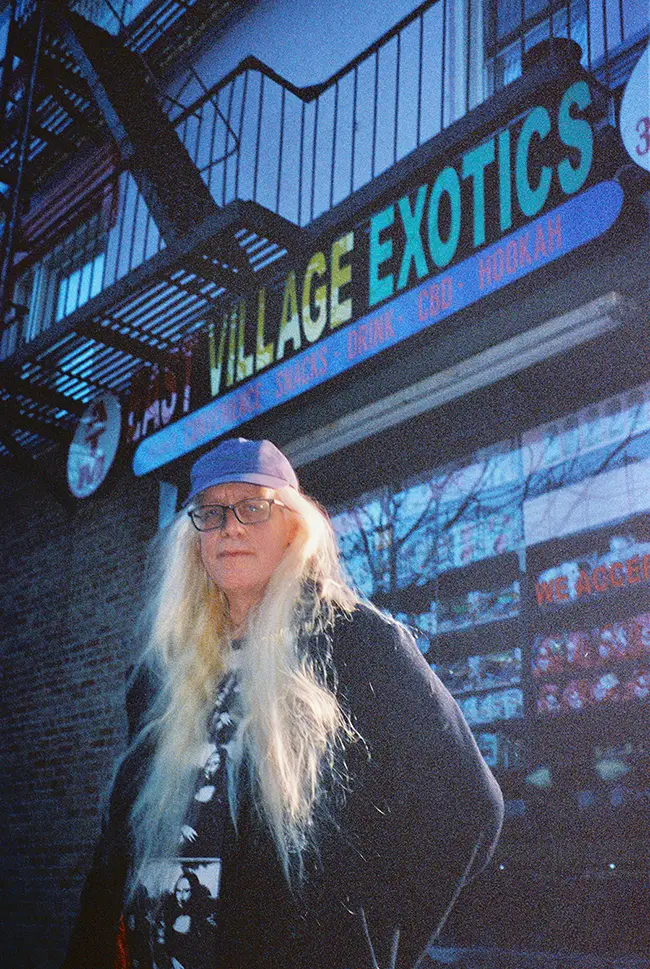 image of Carlo McCormick standing in front of of Village Exotics sign