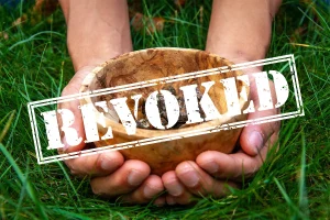 Person holding mushrooms with "revoked" stamp on image
