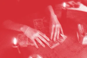 Red Filter on Image of Hands Shuffling Tarot