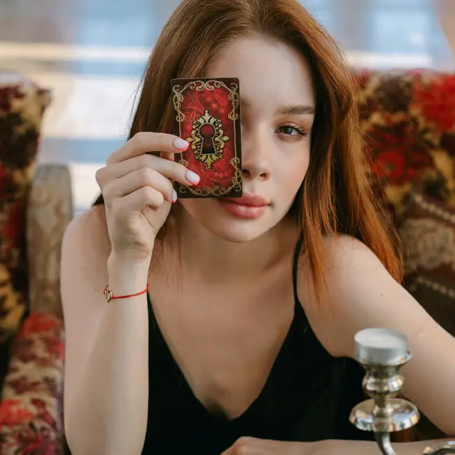 Woman Holding Tarot Card in Front of Face